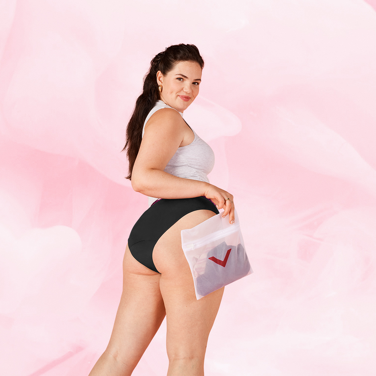 Kvinde holder Vaskepose med undertøj mod tidlig slitage.